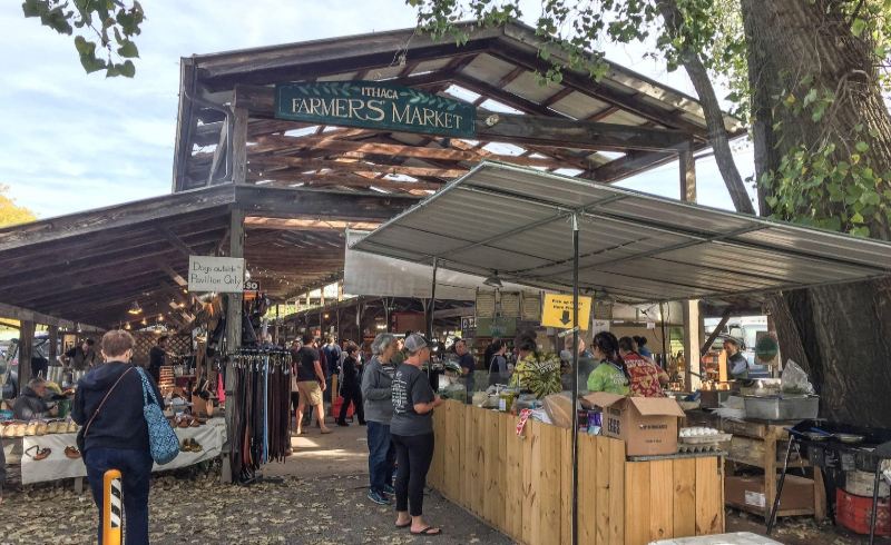 A photo of buyers engaging in conversation and shopping at the Ithaca Farmers Market